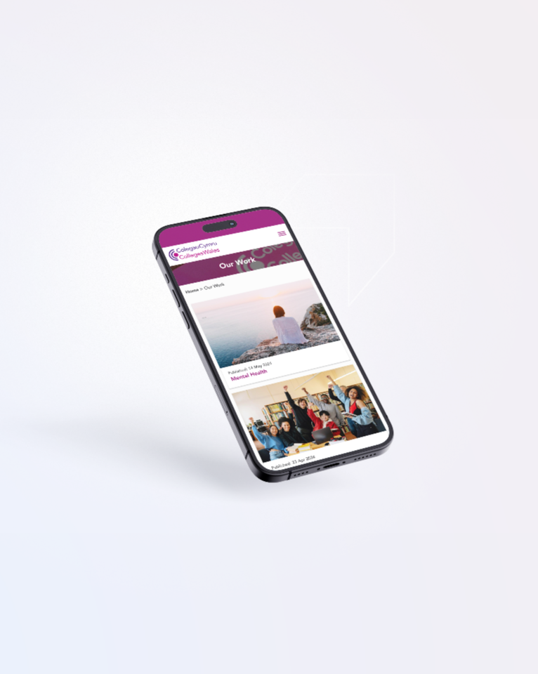 A smartphone displaying a web page with various images and text under the heading "Our Work." The phone is tilted slightly and placed against a plain, light background.