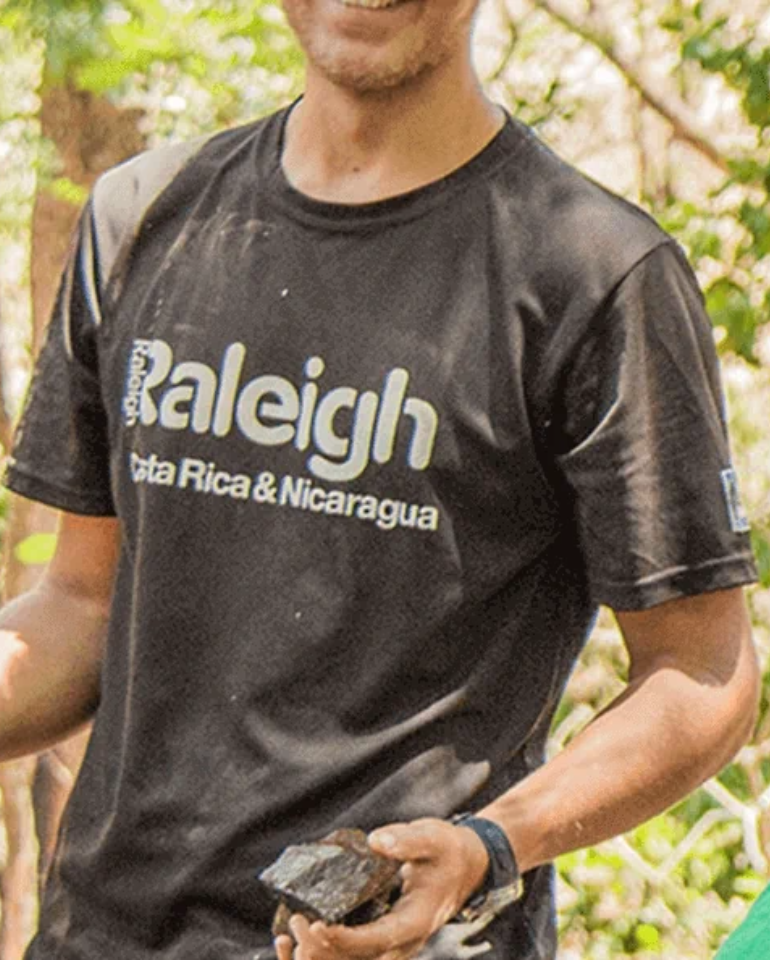 Volunteer wearing Raleigh International T Shirt in black