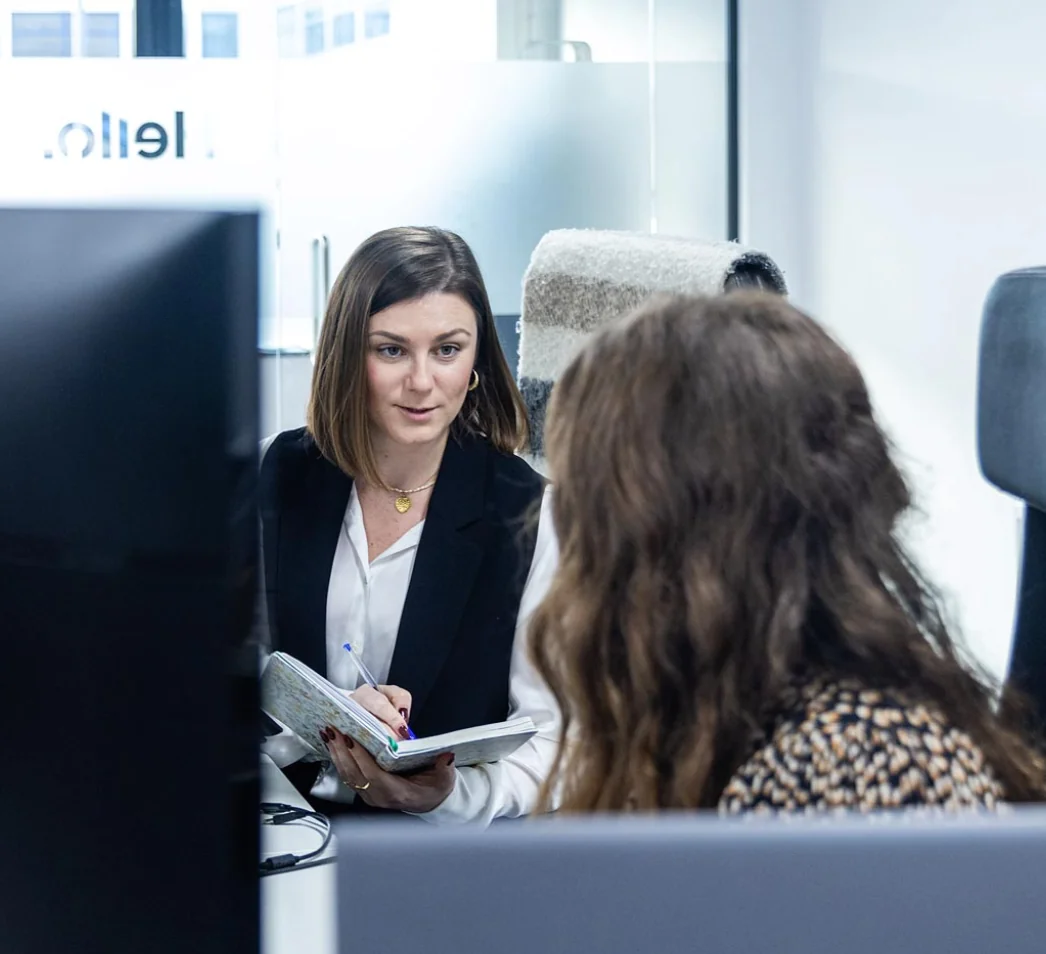 Conversation between two employees at their desk